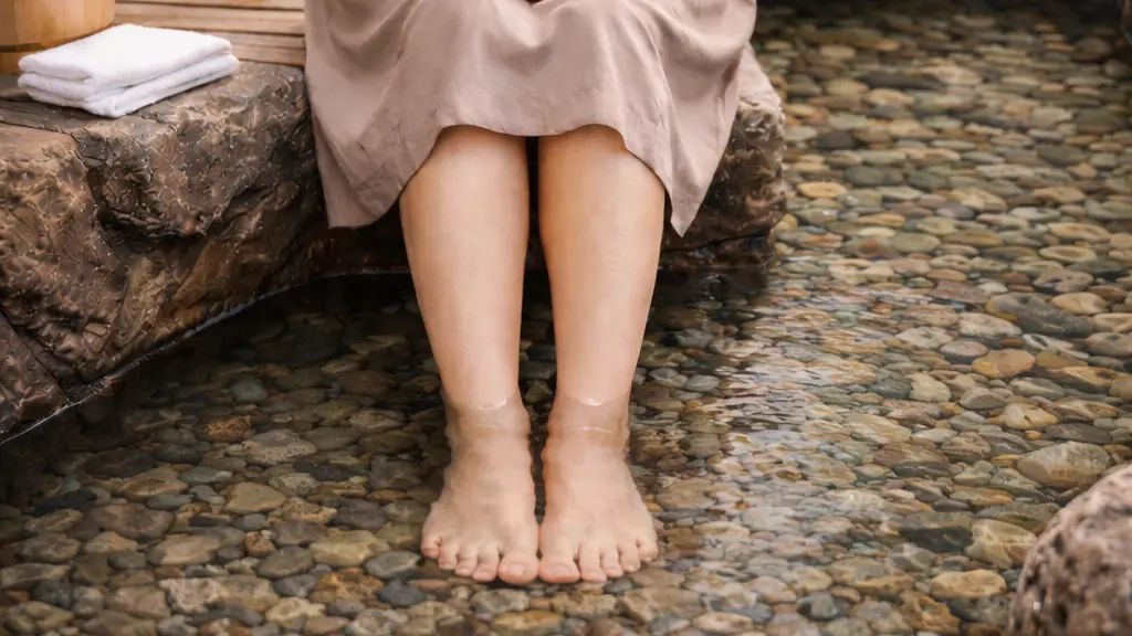 くるぶしの上までお湯に浸かり、足湯（そくとう）を行う女性